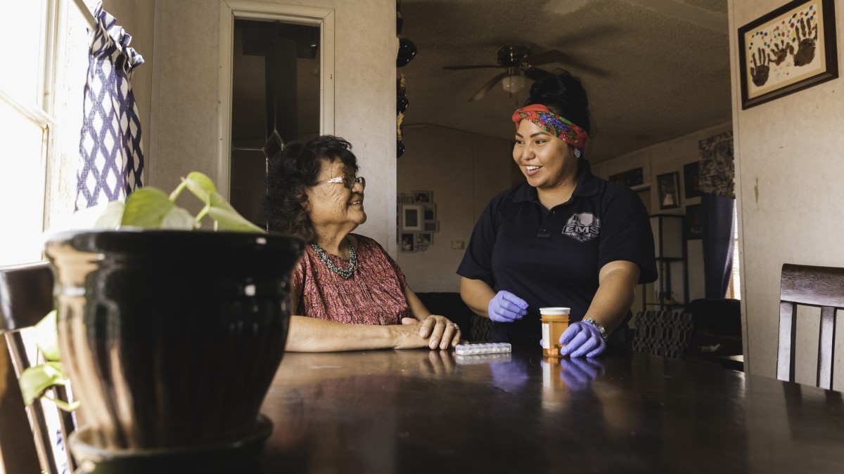 Navajo Una trabajadora de salud comunitario ayuda a una mujer navajo con sus medicamentos